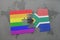 puzzle with the national flag of south africa and gay rainbow flag on a world map background.