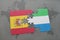 puzzle with the national flag of spain and sierra leone on a world map background.