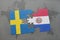 puzzle with the national flag of sweden and paraguay on a world map background.