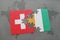 puzzle with the national flag of switzerland and cote divoire on a world map background.