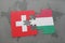 puzzle with the national flag of switzerland and hungary on a world map background.