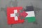 puzzle with the national flag of switzerland and palestine on a world map background.