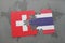 puzzle with the national flag of switzerland and thailand on a world map background.
