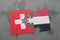 puzzle with the national flag of switzerland and yemen on a world map background.