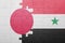 Puzzle with the national flag of syria and japan