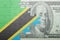 Puzzle with the national flag of tanzania and dollar banknote