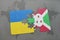 puzzle with the national flag of ukraine and burundi on a world map