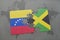 puzzle with the national flag of venezuela and jamaica on a world map background.