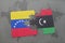 puzzle with the national flag of venezuela and libya on a world map