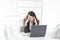 Puzzled businesswoman sitting behind a Desk