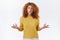 Puzzled, indecisive cute redhead curly woman in yellow sweater, have misunderstanding, raise arms and shrugging troubled