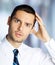 Puzzled, shocked astonished brunette businessman in white shirt and tie, indoors. Young confident business man