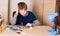 Puzzled teen boy doing school electronic project in his room at