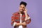 Puzzled tired young african american guy in casual colorful shirt posing isolated on violet wall background studio