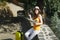 Puzzled traveler tourist woman in casual clothes, hat with suitcase looking on city map holding retro vintage photo