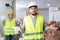 Puzzled worker standing at construction site with screaming female foreman