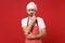 Puzzled young bearded male chef cook or baker man in striped apron white t-shirt toque chefs hat posing isolated on red