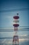 Pylon of Telecommunications with antennas for radio, television and telephone signal broadcasting in a cloudy blue sky.