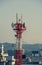 Pylon of Telecommunications with antennas for radio, television and telephone signal broadcasting in a cloudy blue sky.