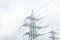 Pylon or transmission tower against a stormy sky. Burst of sunshine behind rain clouds.High-voltage power transmission