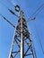 Pylon with wires under high voltage over the railway against the blue sky on a day
