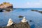 Pyramid of balancing white pebbles, on the rock of a rocky beach