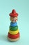 A  pyramid build from colored wooden rings on a vertical stick. Toys for babies and toddlers to joyfully learn mechanical skills