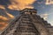 The pyramid of Chichen Itza in honor of the God Kukulkan under a beautiful tropical orange sunset