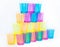 A pyramid of colored cups on a white background - yellow, orange, pink and blue