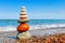 Pyramid of colored pebbles on a background of the summer sea. Concept of harmony, balance and meditation