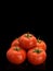 Pyramid combined from five ripe tomatoes covered with drops of water