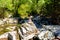 A pyramid of flat round stones stands on a large stone in the middle of a mountain rapid river in the Altai.