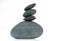 A pyramid of four stones in balance is isolated on a white background