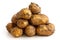 Pyramid heap of unwashed new potatoes isolated on white.