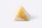 Pyramid made from yellow onyx possesses mystical properties. Souvenir semiprecious stone on a white background