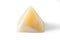 Pyramid made from yellow onyx possesses mystical properties. Souvenir semiprecious stone on a white background