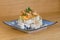 Pyramid of maki roll with fried shrimps, tempura vegetables, sesame and rocket decoration