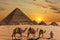 The Pyramid of Menkaure  and the three pyramid companions, the camels and the bedouins in the desert