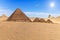 The Pyramid of Menkaure and the three pyramid companions in teh desert of Giza