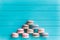 Pyramid of multicolored macaron or macaroons lie on a turquoise wooden background, almond cookies in pastel tones, top