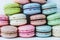 Pyramid of multicolored macaroons on a white wooden background close-up