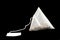 Pyramid shape tea bag isolated on black background with clipping path. Close-up of fresh herbal tea bag isolated over black