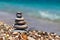 Pyramid of stones on pebble beach near the ocean. Obo from pebbles. Stone tower on the beach. Balance, peace of mind