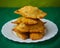 Pyramid of Tasty Mixed Spanish Empanadillas or spanish small pasties on a green background and a dish