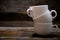 Pyramid of three white cups of espresso coffee on a wooden table.