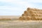 Pyramid of tightly twisted stacks of golden hay at the end of summer with place for copy space. Agriculture concept