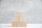 Pyramid of wooden cubes light concrete background.Blank blank space for text .