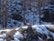 Pyramids of stones on a snowy Sunny glade against a dark slope