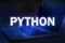 Python text on blue technology background with laptop. Learn python programming language, computer courses, training