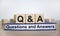 Q and A, questions and answers symbol. Concept words `Q and A questions and answers` on wooden cubes on book on a beautiful whit